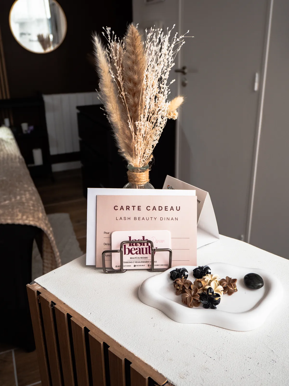 La carte cadeau Lash Beauty Dinan, rose poudré, posée à l'accueil de l'institut